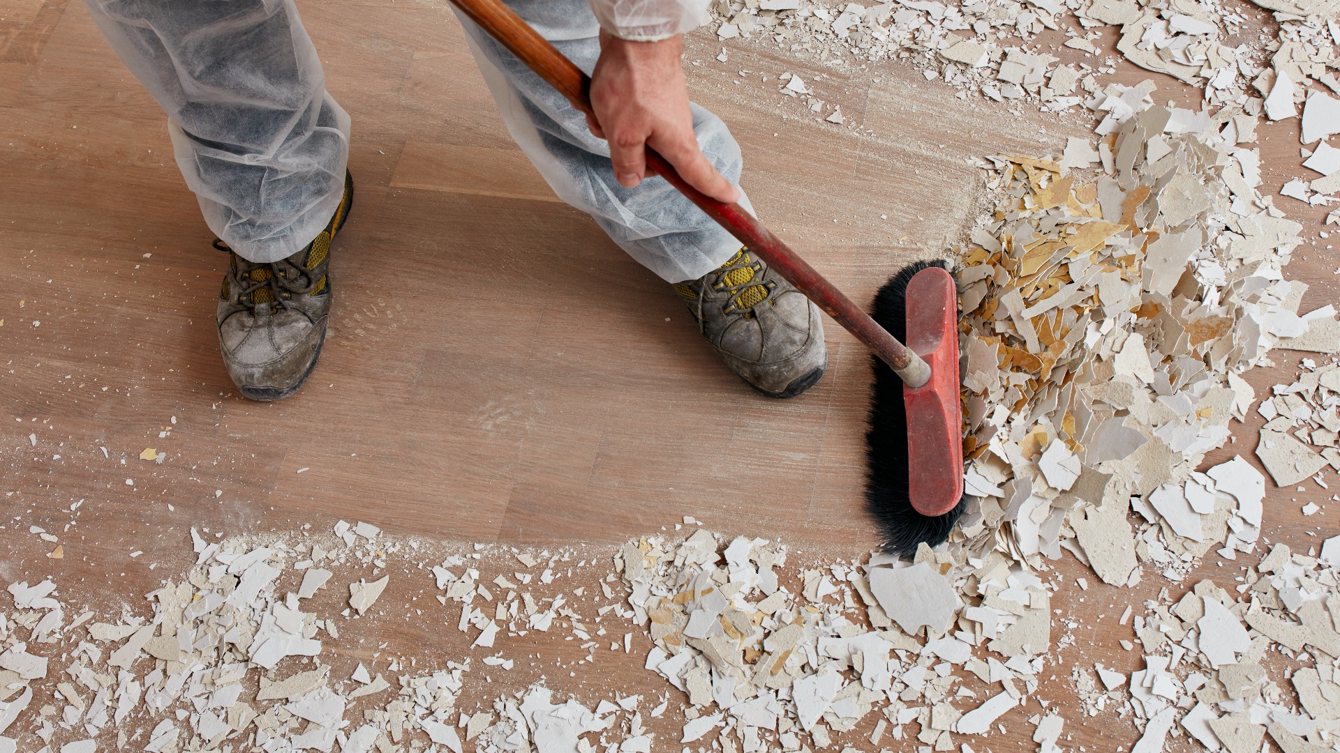 Builder sweeping the floor after renovation jpg