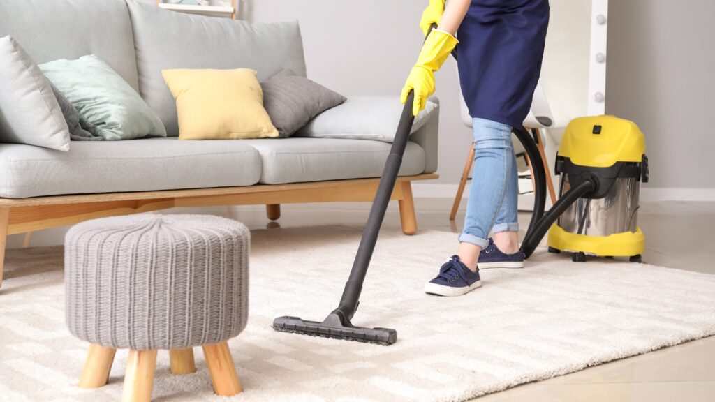 Female janitor with vacuum cleaner in room jpg